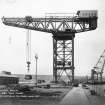 View of testing of 250 tons crane at H M Dockyard, Rosyth, from west wall of main basin looking north.