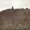 Photograph, distant view of woman standing on top of Elsay Broch. 