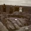 Photograph of group of people around the circle cist at Ackergill Links. 