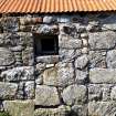 Close-up view of a blocked doorway containing a small window in the SE face of the byre. 