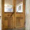 Interior view showing detail of door, including weighted closure system, in stables workshop at The Steading, Nether Blainslie.