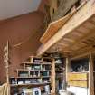 Interior view showing staircase up to hayloft bedroom and bookshelf steps in ground-floor study of house at The Steading, Nether Blainslie.