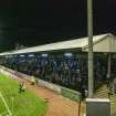 General view of football pitch to west terracing taken from the south. Under floodlights.