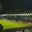 General view of the west covered terracing with the 'away' fans with views to the football pitch and east terracing taken from the north east. Under floodlights.