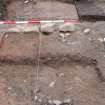 Archaeological excavation, General view of wall 110,  clay floor 114 overlying  earth floor 118 and tree root disturbance deposit 115, Queen Street, Jedburgh