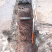 Archaeological excavation, 1 m depth of slot with plastic pipe at 0.6m depth in slot extension, Queen Street, Jedburgh