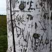 Close-up view of some of the graffiti on the post.
