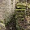 View from north west of water wheel pit. Lade supports in background, tailrace in foreground.