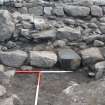 Outermost wall in foreground, with outer outer wall behind, notably large boulder on left, and broch outer wall at back