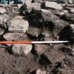 Time Team trench. Behind red end of pole are two steps, pole rests on remaining inner facing stones of outer wall