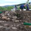 Time Team trench uncovered; outer wall in foreground, first step behind
