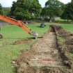 Evaluation photograph, SW end of trench 1 showing shallow topsoil and deep modern plough marks and trench 2 started, Land to SW of Birse Church, Birse, Aboyne