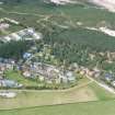 Oblique aerial view of part of the Findhorn Foundation and dunes beyond, Moray, looking NW.