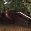 Corranach Knowe: View from the E of the upturned ceramic exhaust pipe attached to the SE face of the control shelter