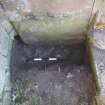 Watching brief, View of small trench excavated at base of gravestone along S transept wall, Coldingham Priory