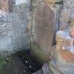 Watching brief, View of small trench excavated at base of gravestone along S transept wall, Coldingham Priory