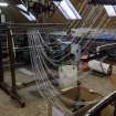 Islay, Bridgend/Redhouses Woollen Mill. Interior, first floor.  View of warping process. Woollen yarns of required colour for the pattern taken from cones or cops (right) and guided towards the warp frame. These are then wound onto a warp beam which is then attached to the loom. The colour arranged yarns are then woven into fabric.