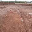 Excavation photograph, Looking E. Shorter ranging rod beside N end of wall slot 8, new Mearns Academy site, Laurencekirk Aberdeenshire 