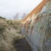 View of WW2 Nissen Hut W4 and the base of its (WW1) blast mound. Note the concrete raft on which the hut sits.