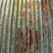 Detail of corrugated iron roof of Nissen Hut magazine W4. A green colour scheme/camouflage can be seen as well as rust.