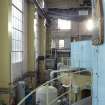 Interior. Carsfad  Hydro Electric Power Station. Turbine/Power House. View from west along south side of building towards Operating Room at mezzanine level. The generator sets, Units 1 and 2, on the right