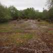 View to the ESE of the cement floor to where it is crossed by the Narrow Gauge Railway fronting the deciduous scrub woodland in the background