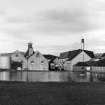 General view of distillery complex with dam in foreground.