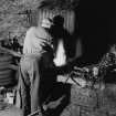 Mr D McCallum working at the middle forge and bellows at Machrimore Smithy, Kintyre