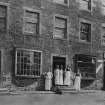 View of the Village Store from the street showing staff grouped on the front steps of the building