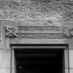 Detail of inscribed lintel over door on West side