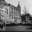 Exterior view from south west - Princes Street gardens showing street scene; pedestrians, cars and bus.
