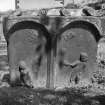 View of headstone for J.P. C.B., 1763: two panels with a figure in each, sun over left figure, moon over right.