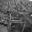 View of Castle Law fort and settlement showing the souterrain during the excavation in 1932. Dr Margaret E C Stewart is in the photograph.