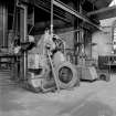 Paisley, MacDowall Street, Caledonia Engineering Works, Interior
View of boiler shop looking NW showing punching and shearing machine which is made by Hugh Smith and Company, Possil. Above punching and shearing machine is 10cwt crane attached to overhead crane track support