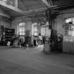 Paisley, MacDowall Street, Caledonia Engineering Works, Interior
View of textile machine department looking SE showing grinder and gear cutter to left and formans office to right (line shaft drive to machine)