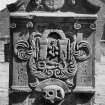 Perth, Greyfriars Burial ground.
View of the gravestone of Andrew Kippen, 1760.
Broken curving pediment with a central winged soul, crest and putti between roses. The lower part of the stone contains the tools of a glover (stretchers, gloves, shears and buckle) between fronds, and a large skull and bone with a Memento Mori riboon. Insc: 'AB,AKE, KL, KBK.'