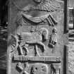 Perth, Greyfriars Burial Ground.
View of the gravestone of the Peter family, 1753. A pointed stone with a winged soul and the date, '1777' inscrobed around a draped festoon. A man in a frock coat approaches a horse pulling a cart across a Memento Mori ribbon. A pair of crossed bones, a skull and an hourglass are below the horse.