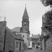 Falkland, High Street, Town Hall
View from SE showing SSE front of Town Hall steeple with cottage in foreground and post office in background