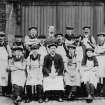 Edinburgh, 87 Giles Street, The Black Vaults.
View of a group of brewery workers in aprons and flat caps posed in front of large doors.