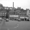 View from W showing WSW front of numbers 62-68 George Street and WSW front of distillery office block with maltings and chimney in background