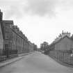 General view looking NW along Teith Road showing memorial, houses and part of primary school