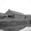 View from W showing WNW and SSW fronts of W block with part of E block in background and canal in foreground