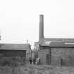 View from NE showing part of ENE front of main blocks with S block and chimney in background