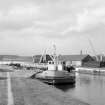 View from SSE showing workboat at N end of Muirtown Basin with smithy on left and crab winch and workshops in background