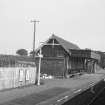 View from SSW showing SW and SE fronts of N building with part of footbridge in background