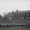 View from N showing NE front of workshops and houses