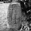 Upright stone bearing sword in relief and sunken cross.
Original negative captioned: 'Stone with Sword and Cross at St Meddan's Churchyard, Fintray 1911'.
