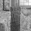 Cross-incised stone reused as jamb of church window.
Original negative captioned: 'Sculptured stone in North-East Window of Parish Church Ellon 1910 / 2 ft. 6 inches long 1 ft. broad 8 in. thick to edge of window frame.".
