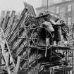 Glasgow, Hutchesontown.
Men pouring concrete into the moulds for the 'legs' of the block.