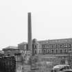 View from N showing part of NE front of main block with chimney in foreground